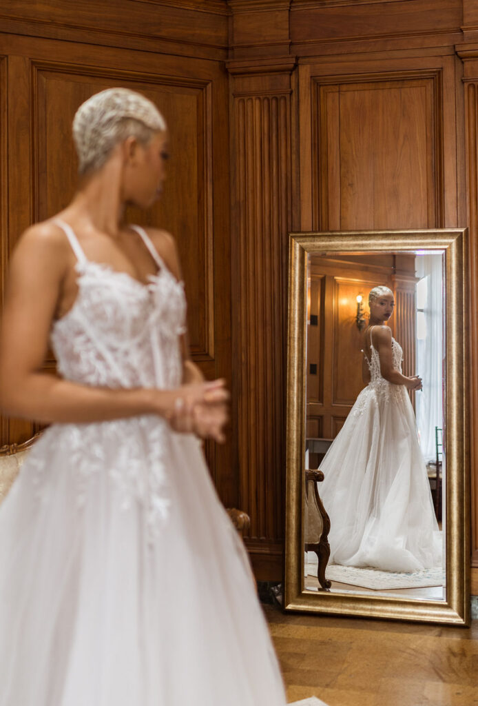 Bride looking at herself in a mirror at Michigan Wedding Venue the Treasury