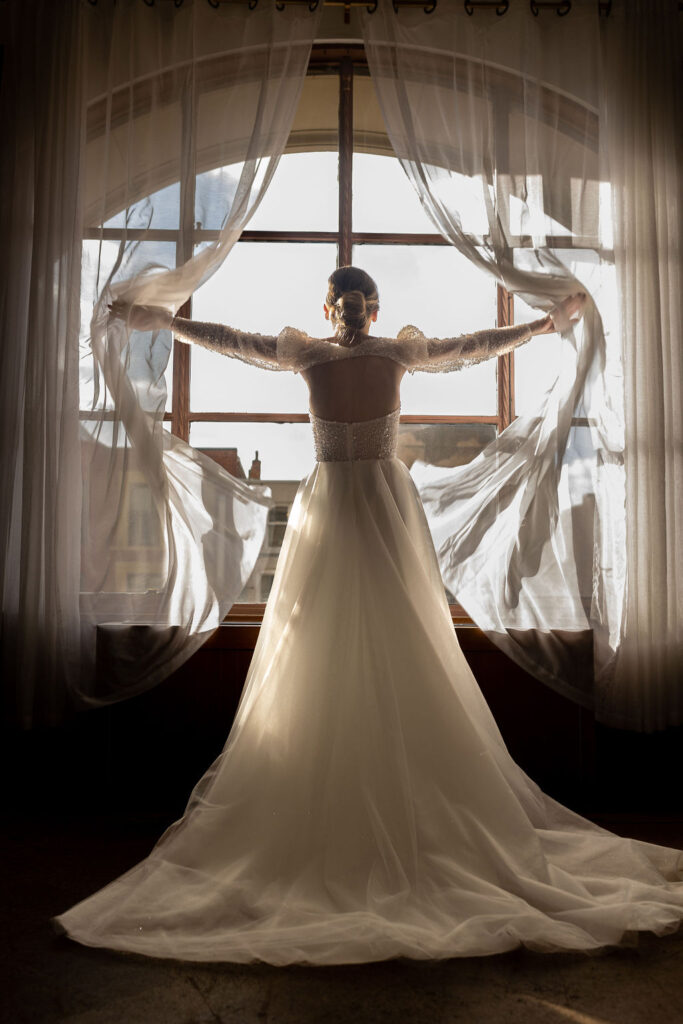 Bride opening curtains in bridal suite at the Treasury in Pontiac MI