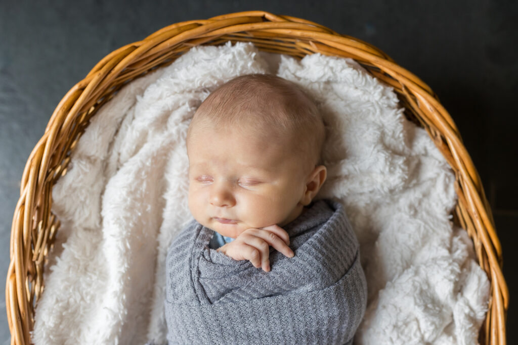 Newborn baby in basket for in home newborn photography session by Savvy Shoots Photography