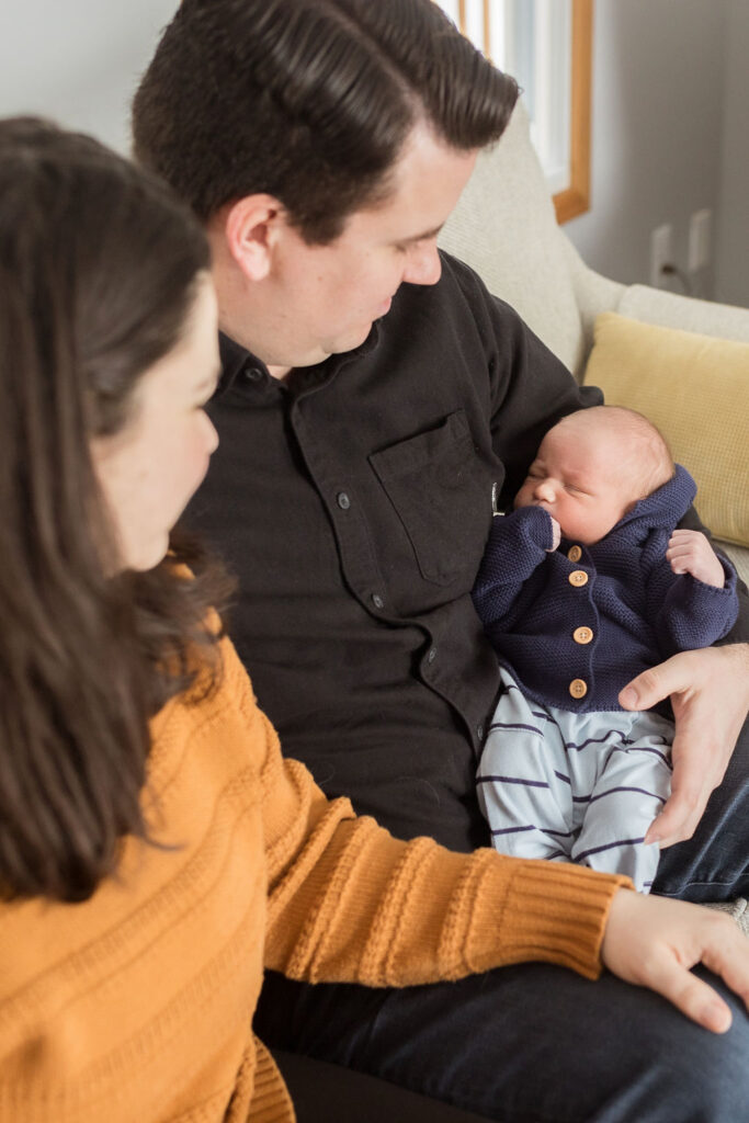 Mother and father holding baby for newborn photos in Oakland Michigan