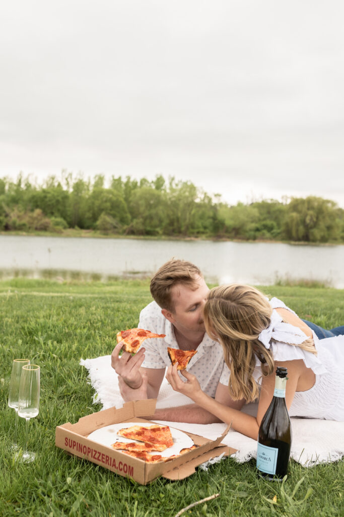 Man and woman kissing eating pizza during engagement photos in Detroit