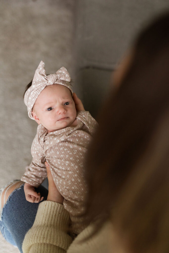 Mother holding baby for newborn photos in Sterling Heights Michigan