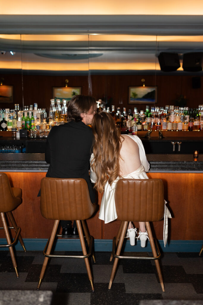 Man and woman sitting at bar during Detroit engagement photography with Savvy Shoots Photography