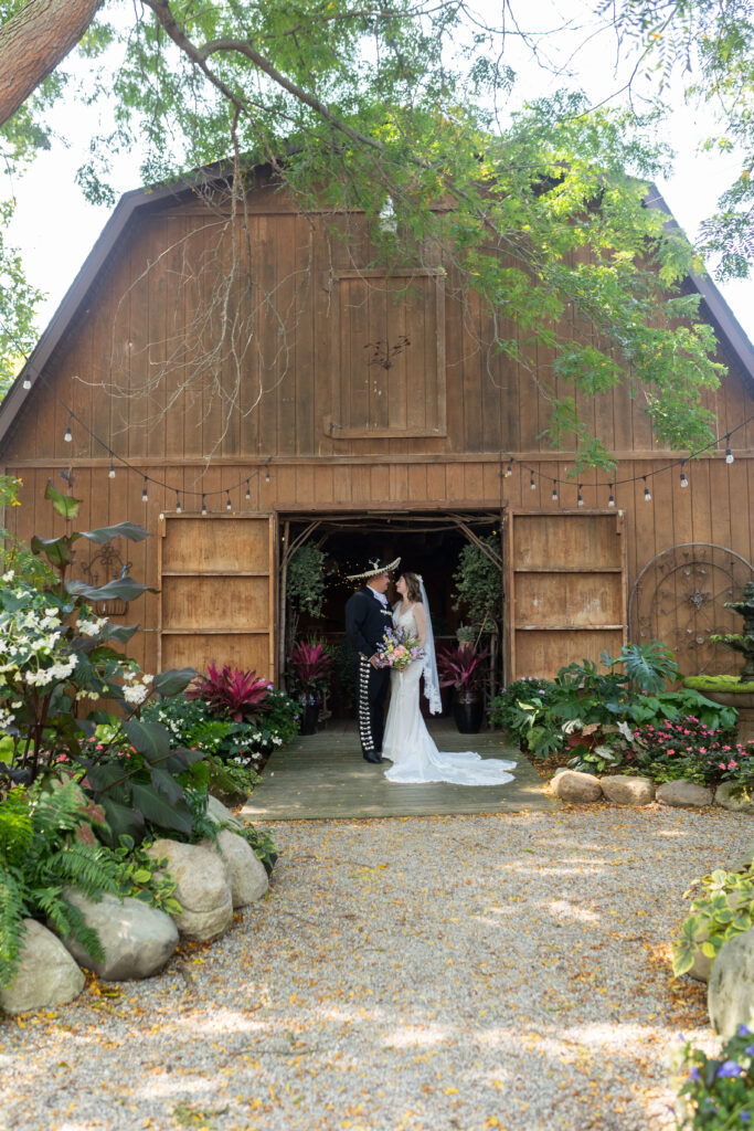 Bride and groom in front of Barn at Everlastings in the Wildwood in Owosso MI