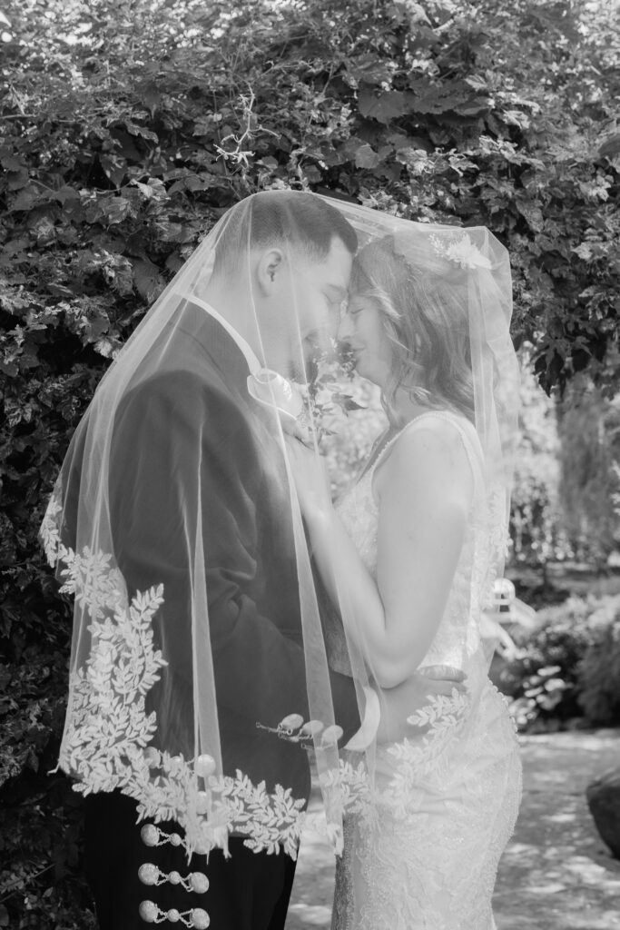 Bride and groom under veil at Everlastings in the Wildwood in Owosso MI