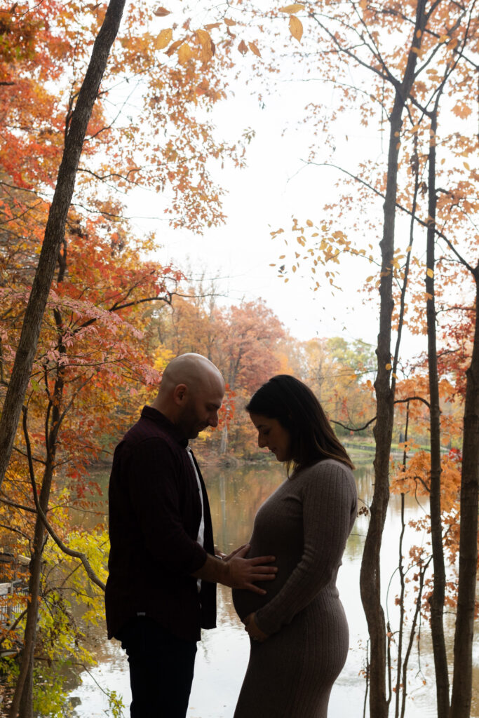 Man and woman facing each other taking maternity photos in Southfield MI