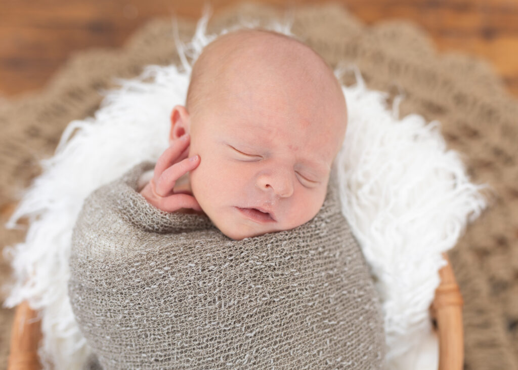 newborn posed in basket during newborn photography in royal oak