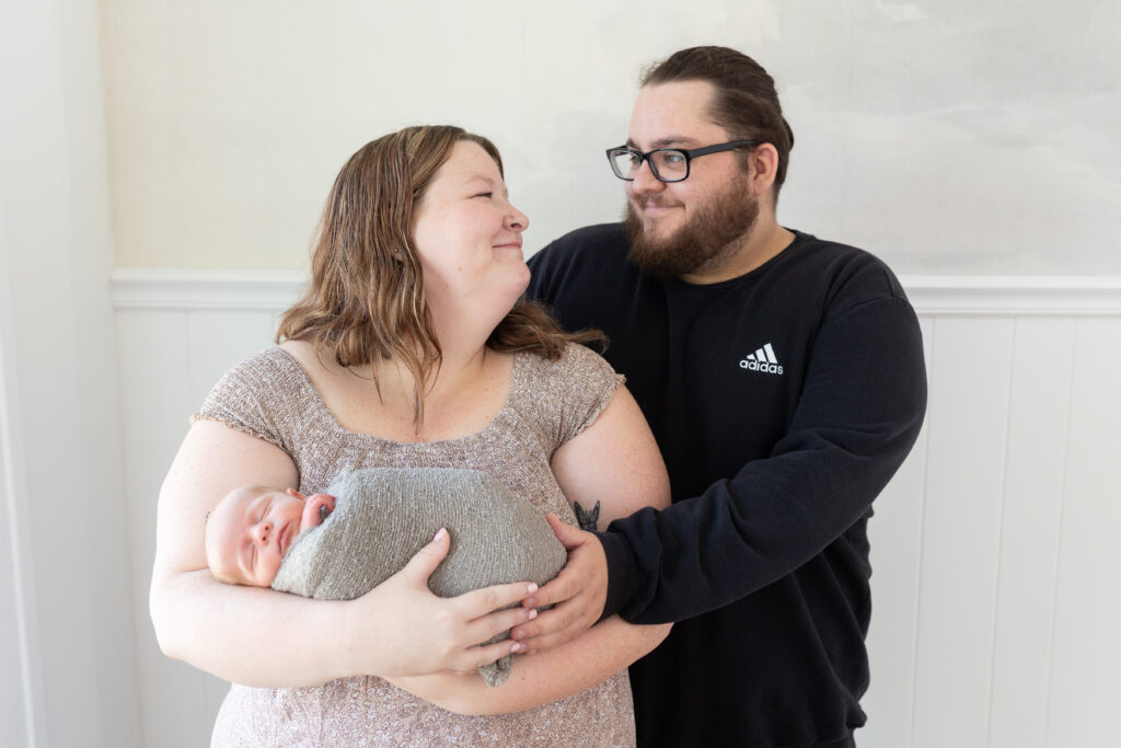 Mother and father holding newborn baby during newborn photography in Royal Oak MI