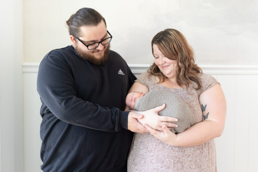 Mother and father holding newborn baby during newborn photography in royal oak