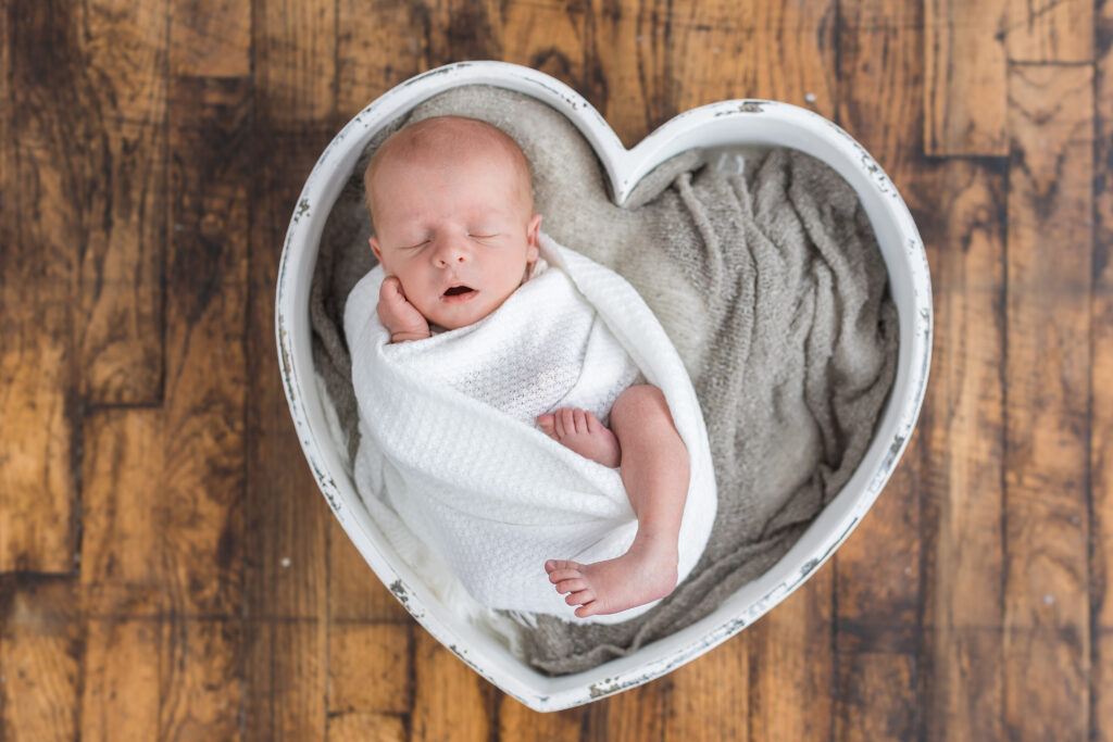 Newborn baby in heart box during newborn photography in Metro Detroit
