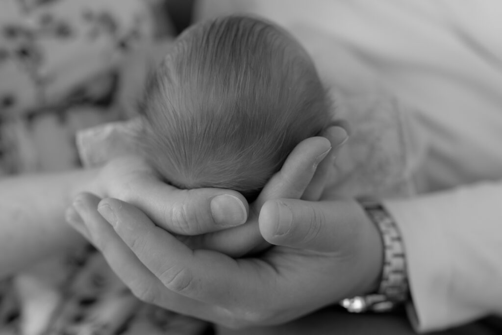 Parents holding baby during newborn photoshoot in Royal Oak Michigan