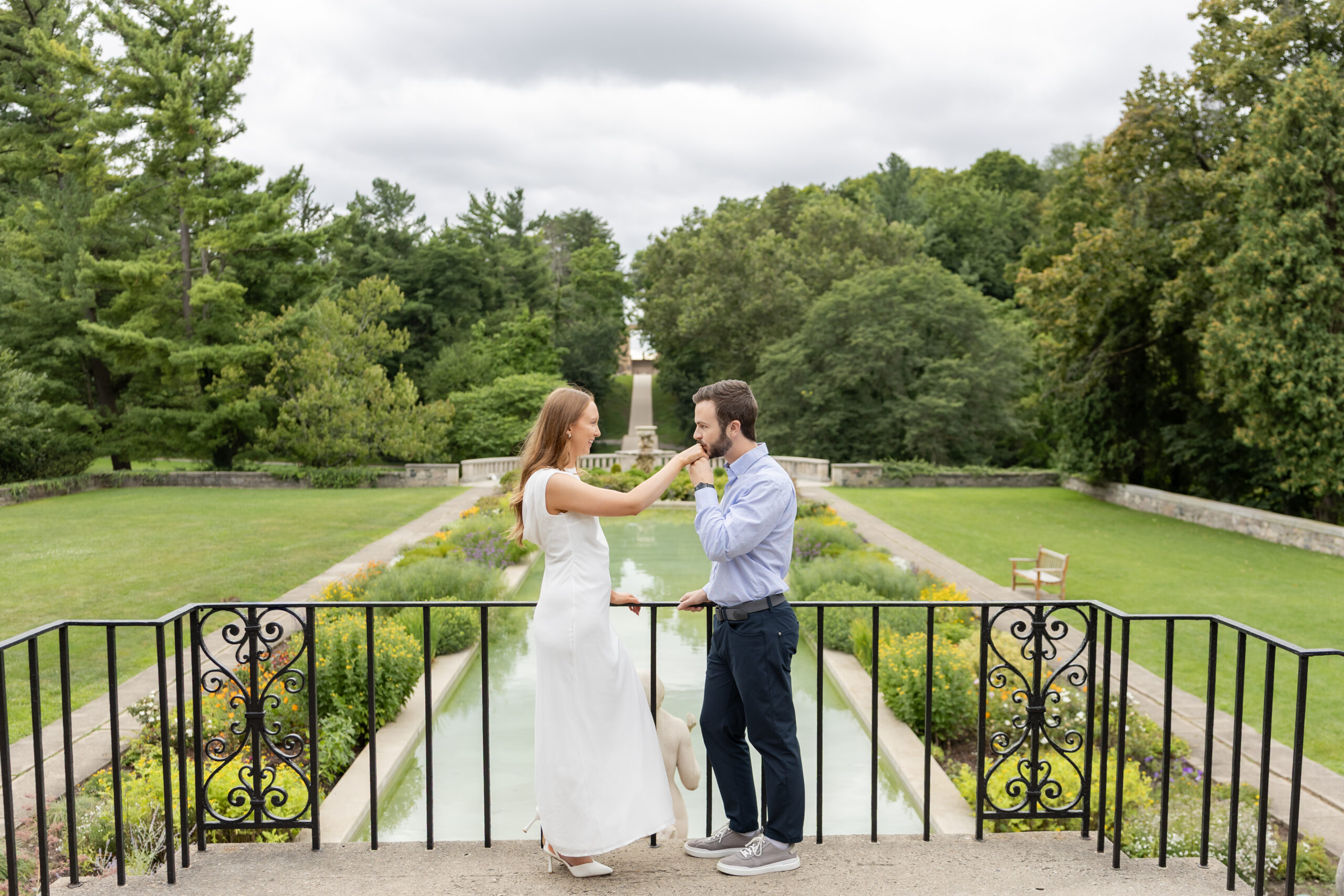 Man kissing woman's hand during engagement photography at Cranbrook