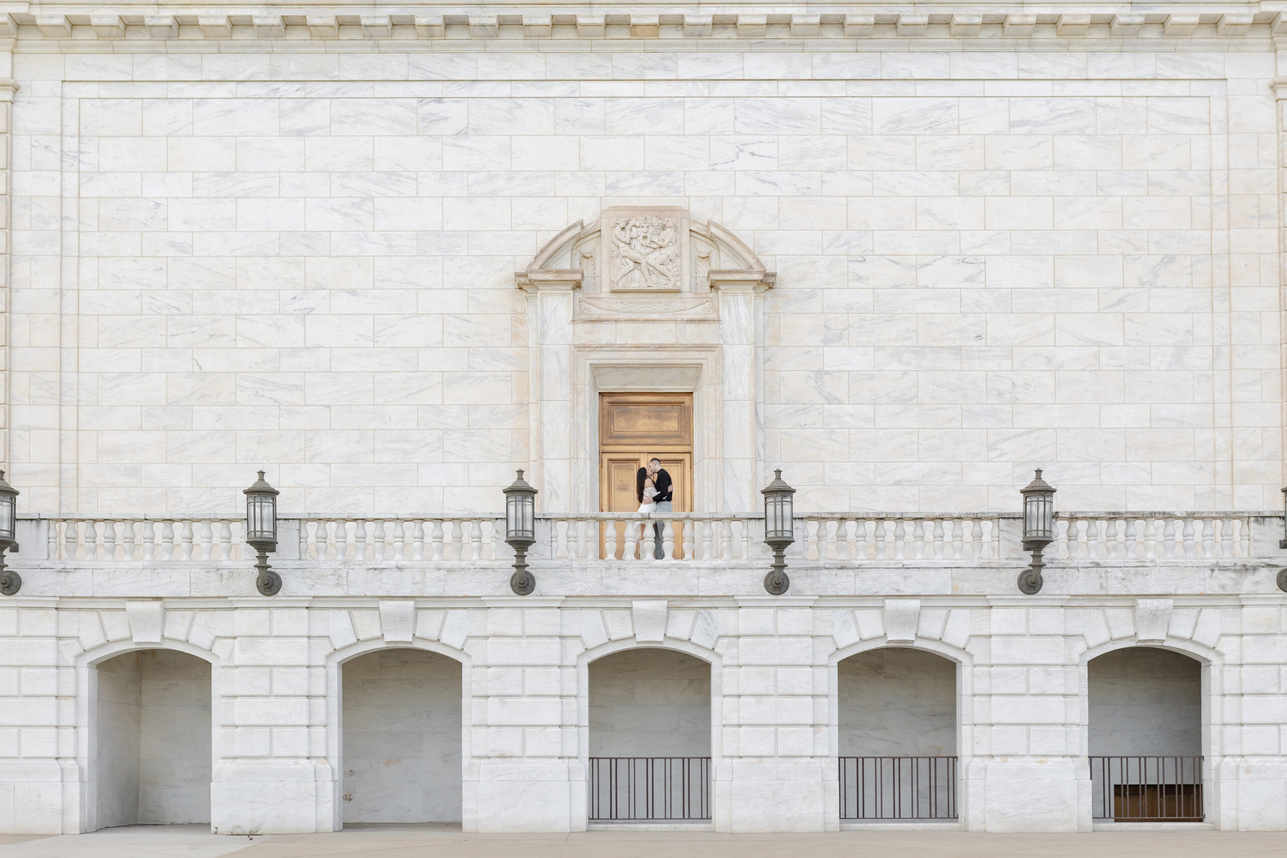 Man and woman kissing at Detroit Institute of Arts during engagement photos