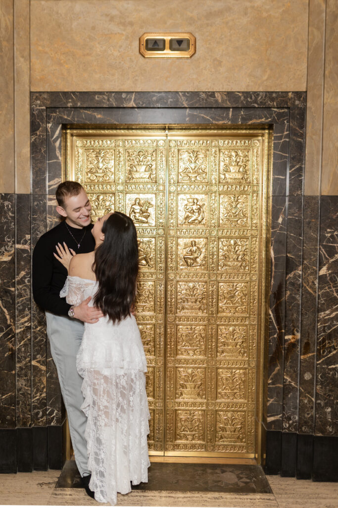 Man and women looking at each other near elevator during Detroit engagement photos