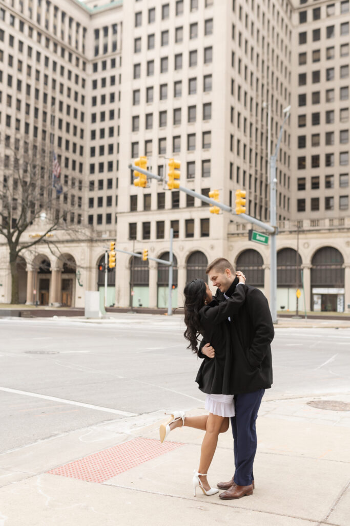 Man and woman kissing during Detroit engagement photos