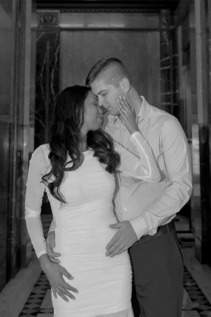 man and woman posing for Fisher building engagement photos