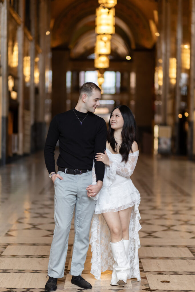 Man and woman smiling at each other during Downtown Detroit engagement photography