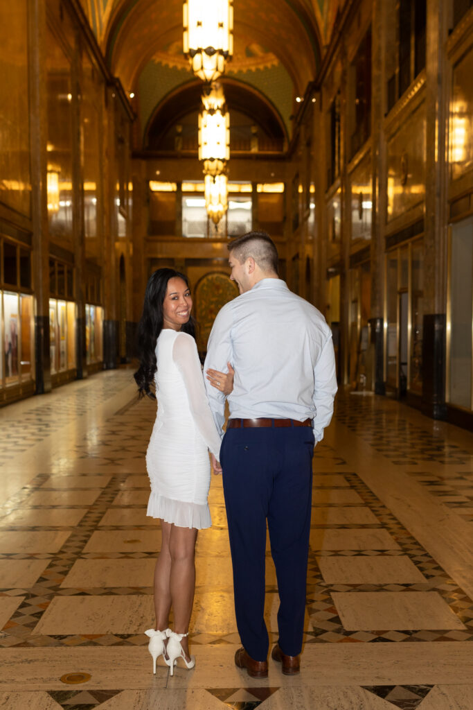 Man and woman taking Detroit engagement photos at Fisher Building