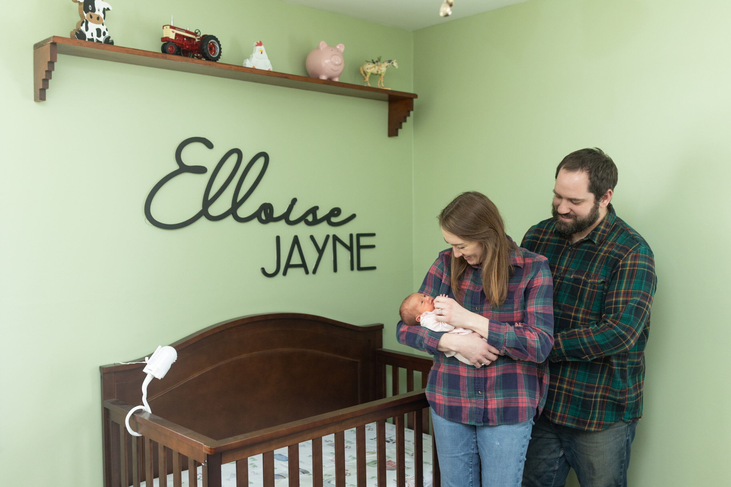 Mother and father look at Baby during in home newborn photography in Waterford MI