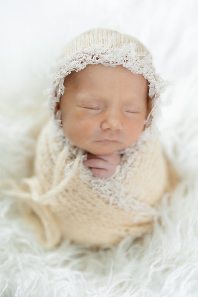 Baby wrapped in swaddle for newborn photography in Waterford mI