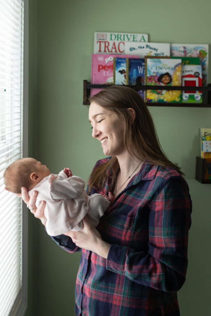 Mother looking at baby during in home newborn photography in Waterford