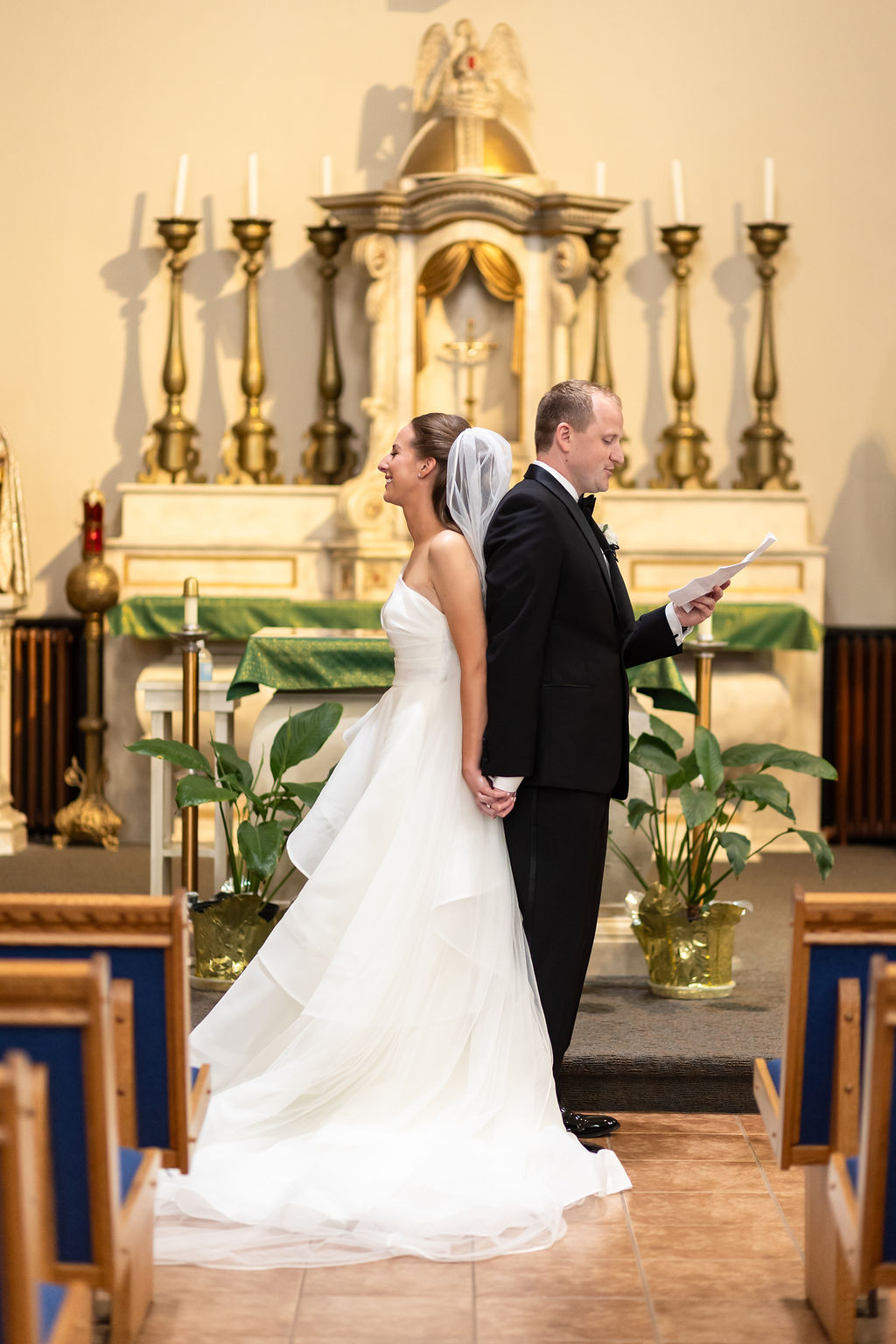 Bride and groom hold hands during first touch at St. Anne Detroit