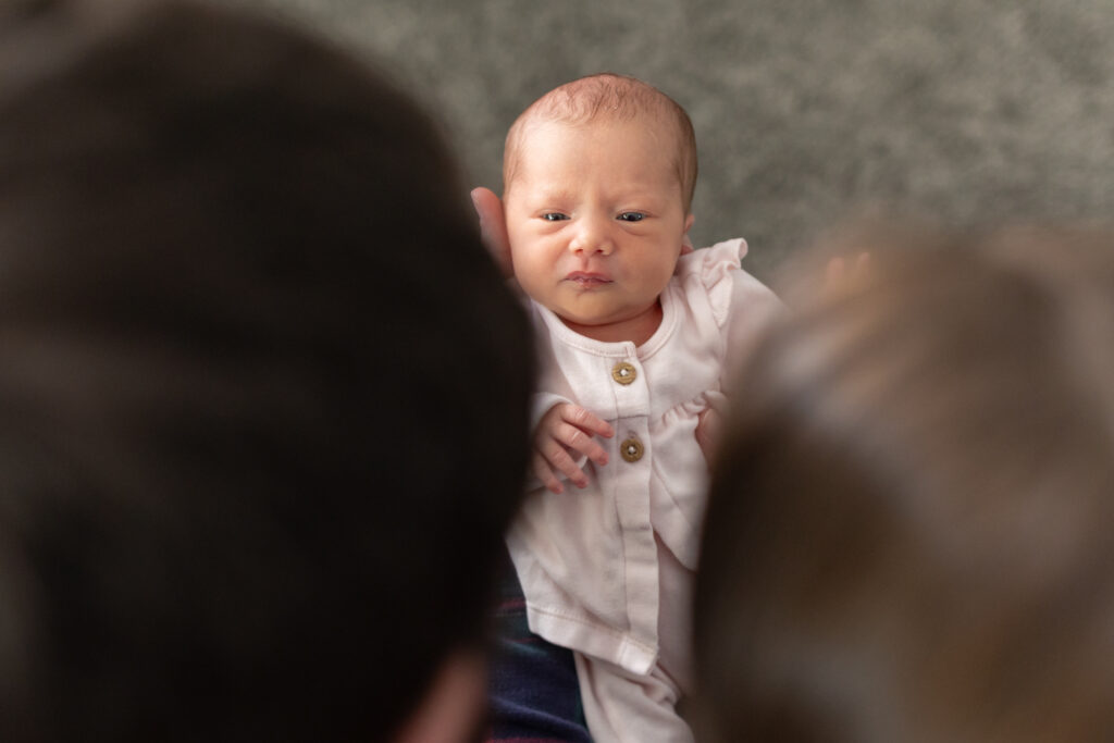baby looking at parents during in home newborn photography in Waterford MI