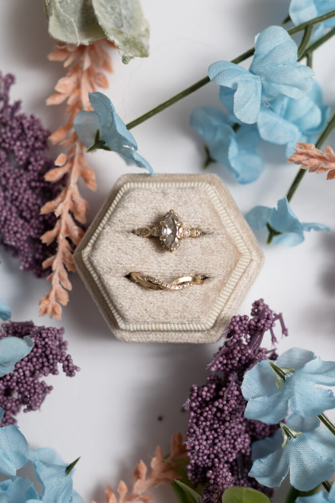 Wedding rings in box surrounded by flowers for wedding detail photos