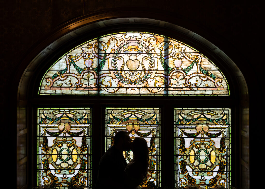 bride and groom kissing on wedding day at The Whitney during Detroit wedding photography