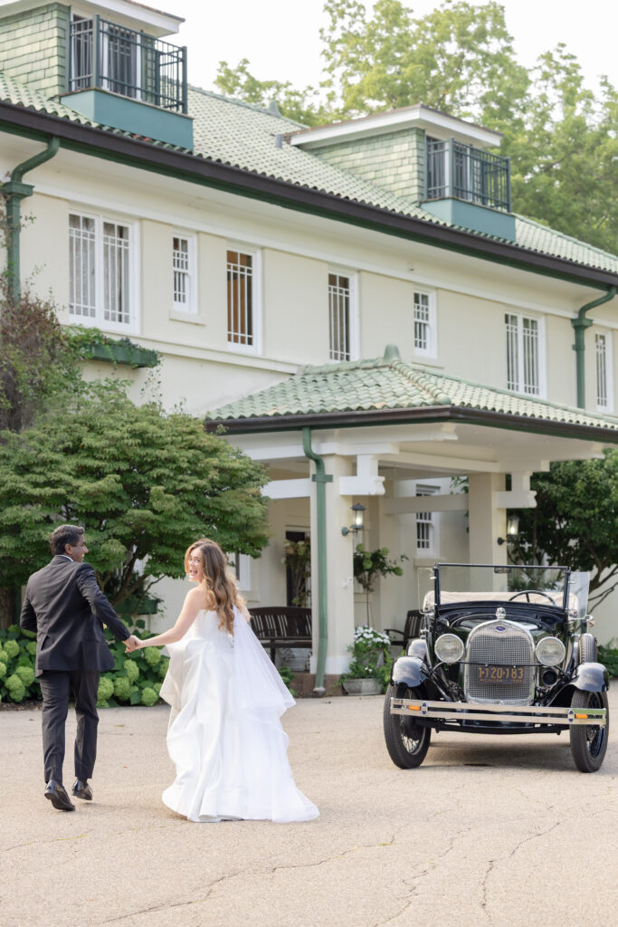 Bride and groom running away toward Belvedere Estate