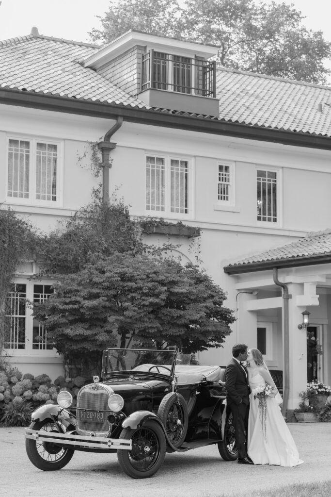 Black and white photo of bride and groom in front of Belvedere Estate during West Michigan wedding photography
