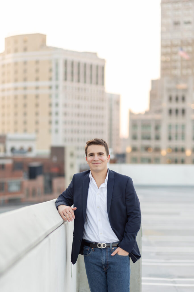 Boy leaning on rooftop wall for Senior photos in Downtown Detroit
